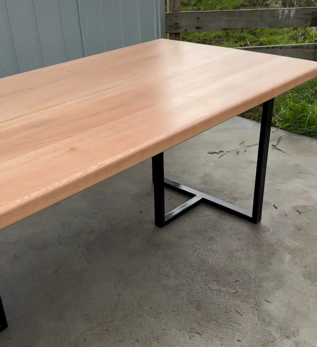 Mesa de comedor de tapa clara con estructura de fierro negro